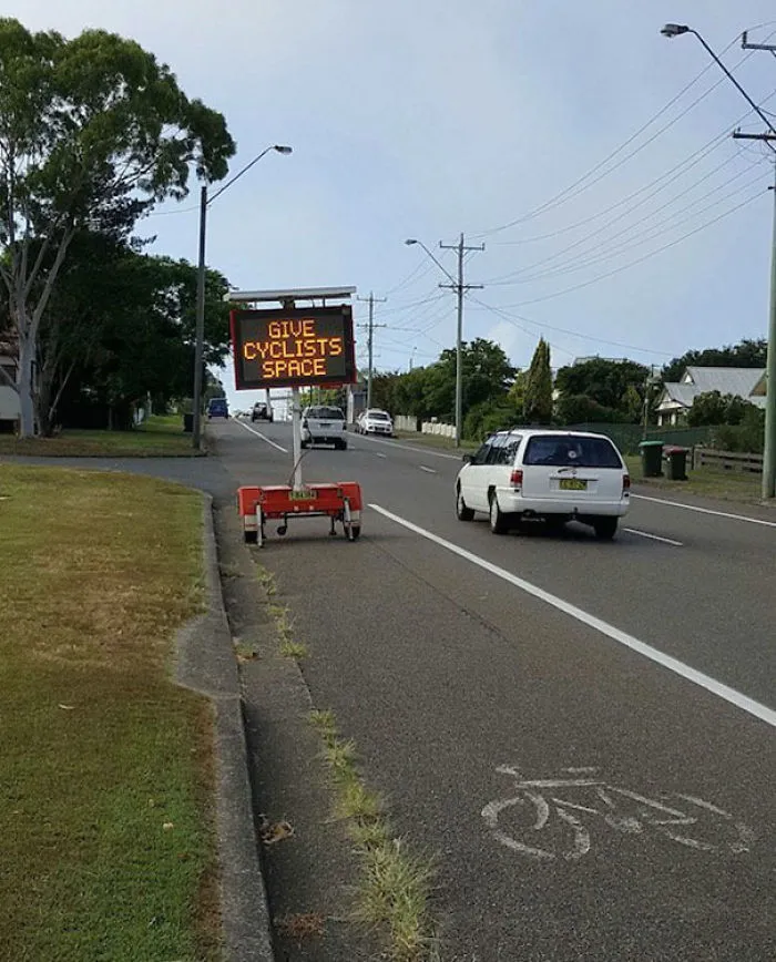 Sign advising "Give Cyclists Space" is placed in a bike lane, demonstrating a job fail.