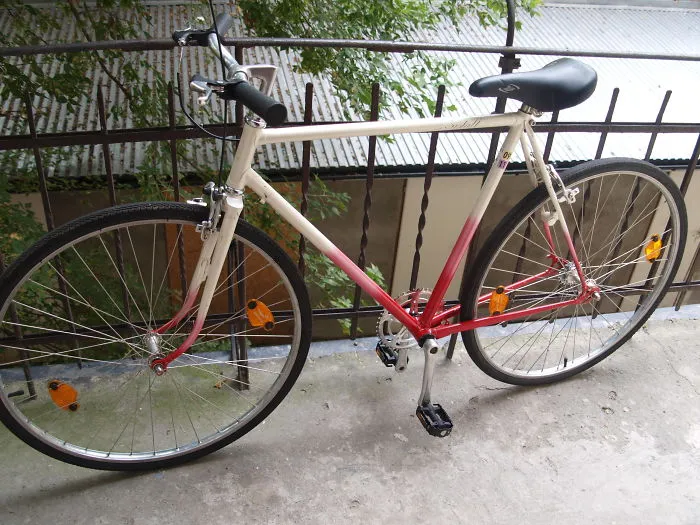 Bicycle with pedals incorrectly attached on one side, illustrating a setup failure.