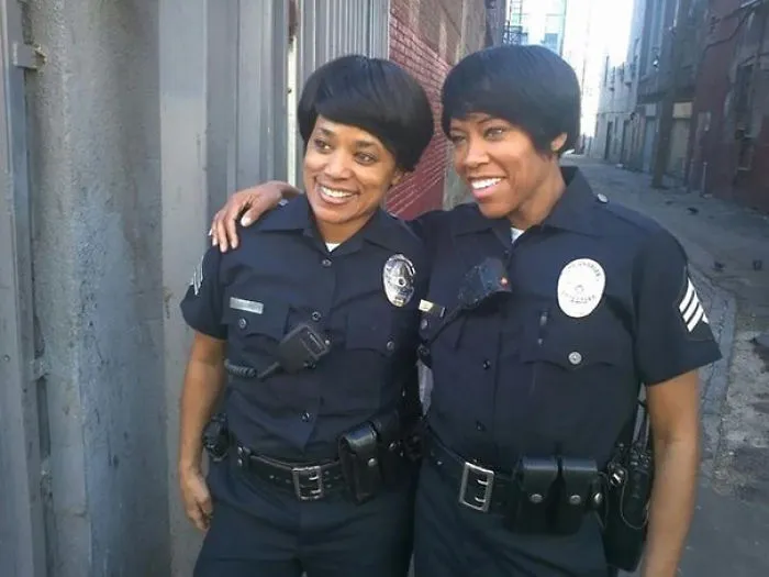 Two women dressed as police officers standing closely in an alley, showcasing celebrity body doubles in Hollywood.