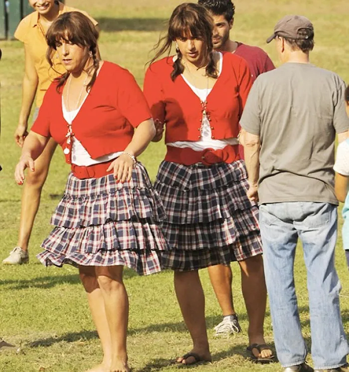 Two women wearing matching red cardigans and plaid skirts outdoors, illustrating Hollywood celebrities’ body doubles.