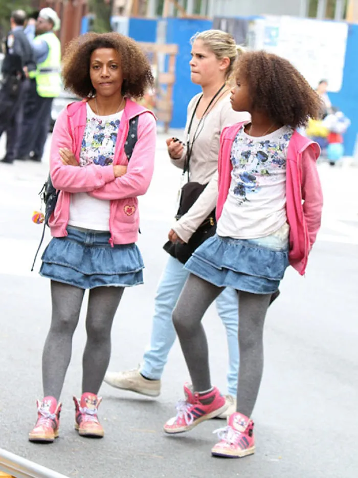 Two women wearing matching outfits standing on a city street, illustrating Hollywood celebrities’ body doubles concept.
