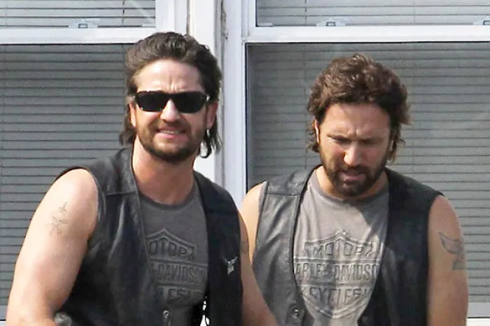 Two men in sunglasses and leather vests posing outdoors, illustrating Hollywood celebrities body doubles concept.