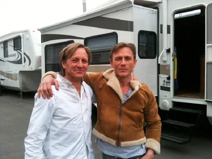 Two men standing together near trailers on set, illustrating Hollywood celebrities’ body doubles in action.