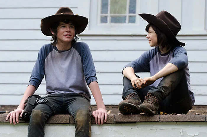 Two young people in hats and casual clothes sitting and talking, illustrating Hollywood celebrities’ body doubles concept.