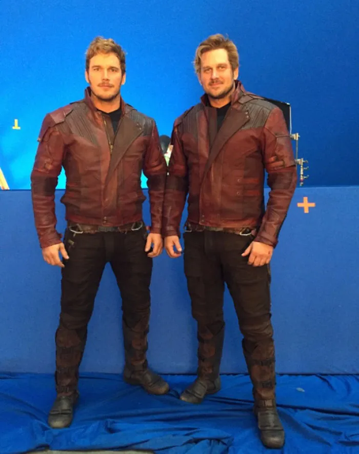 Two men dressed identically in maroon jackets and black pants, showcasing Hollywood celebrities’ body doubles.