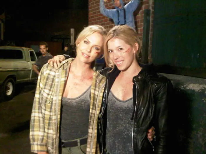 Two women with bruised faces posing together on a dark street, representing celebrities’ body doubles in Hollywood.