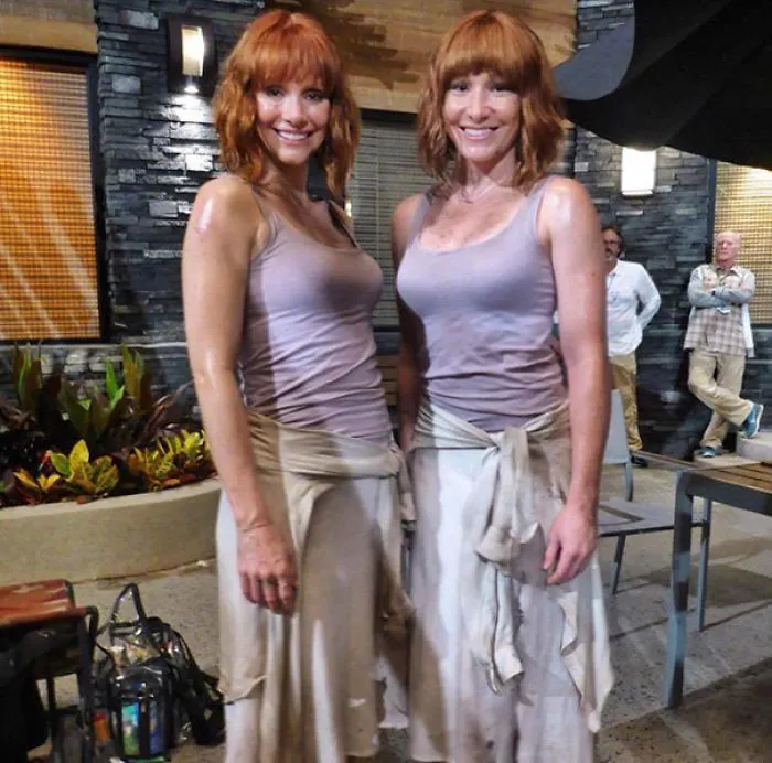 Two women with red hair wearing similar outfits as celebrity body doubles on a Hollywood movie set.