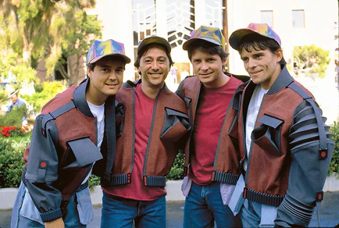 Four men dressed as characters with futuristic jackets and caps, illustrating Hollywood celebrities’ body doubles concept.