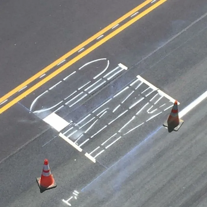 Incorrectly painted road lines next to traffic cones, reflecting job failure.