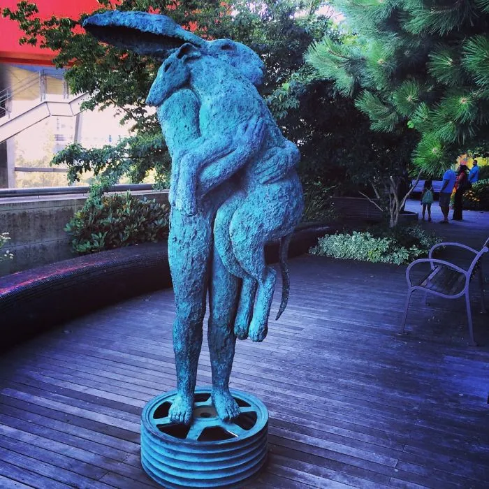 Rabbit-headed Human Standing On A Tire Rim While Hugging A Dog, Portland, Oregon