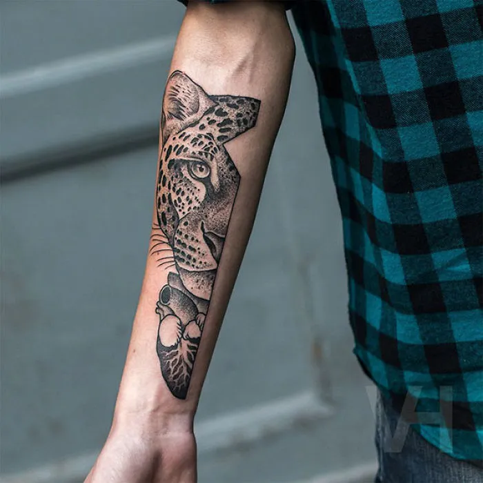 Symmetrical tattoo by Valentin Hirsch on forearm, blending nature and geometry with a leopard design.