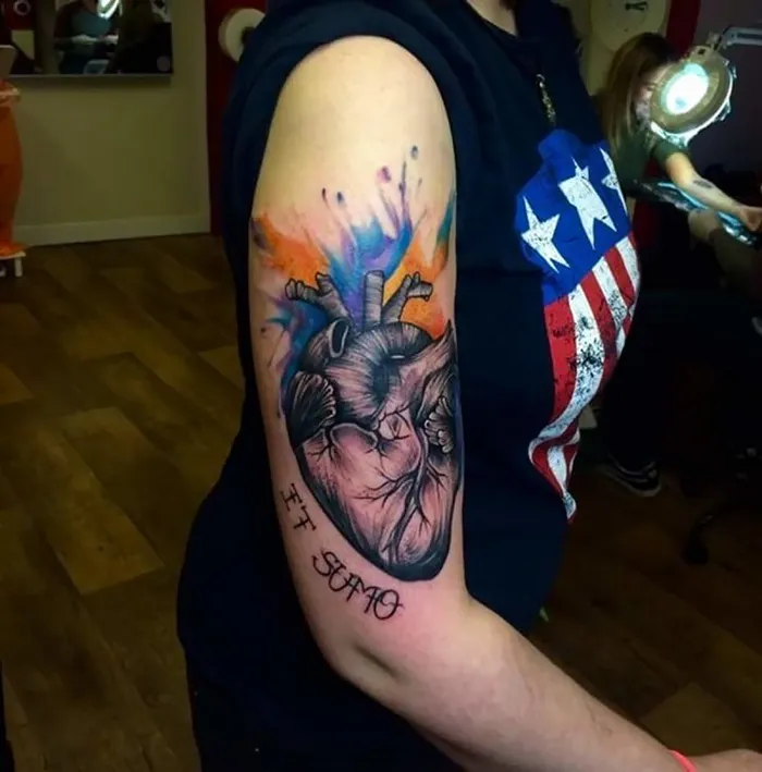 Arm tattoo covering a scar, featuring a colorful anatomical heart design with the words "I Ti Amo."