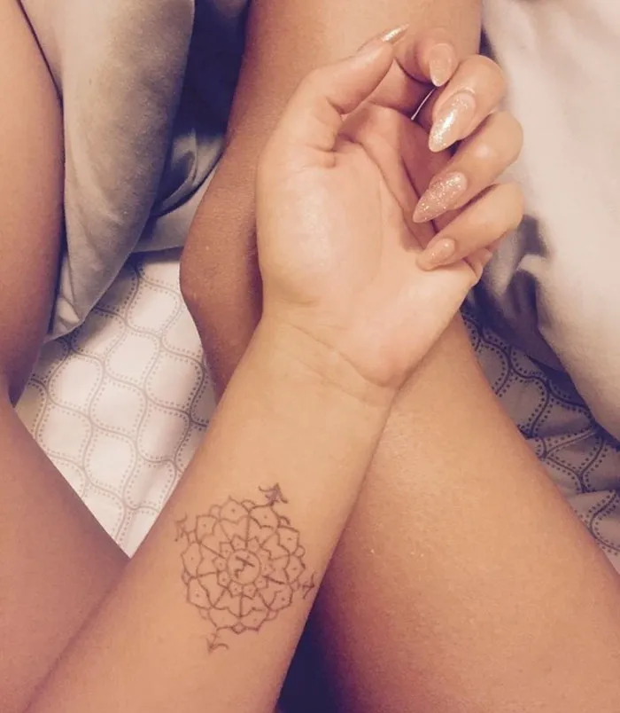 Intricate mandala tattoo covering a scar on a forearm, symbolizing personal transformation and healing.