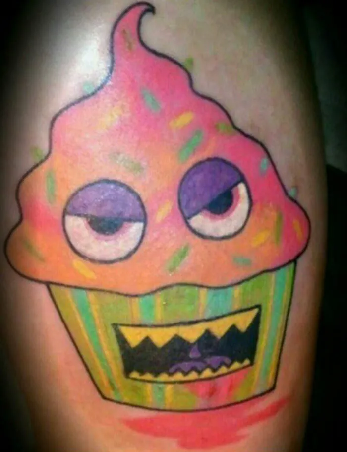 Colorful cupcake tattoo covering a scar, with a playful and quirky design.