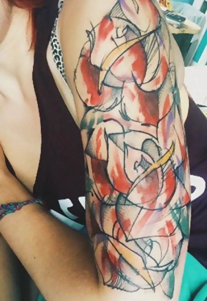 Abstract scar-covering tattoo on a person's upper arm with vibrant colors.