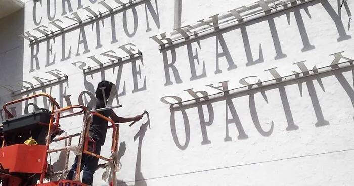 Typographic Shadow Graffiti Turns Boring Building Into Ever Changing Masterpiece