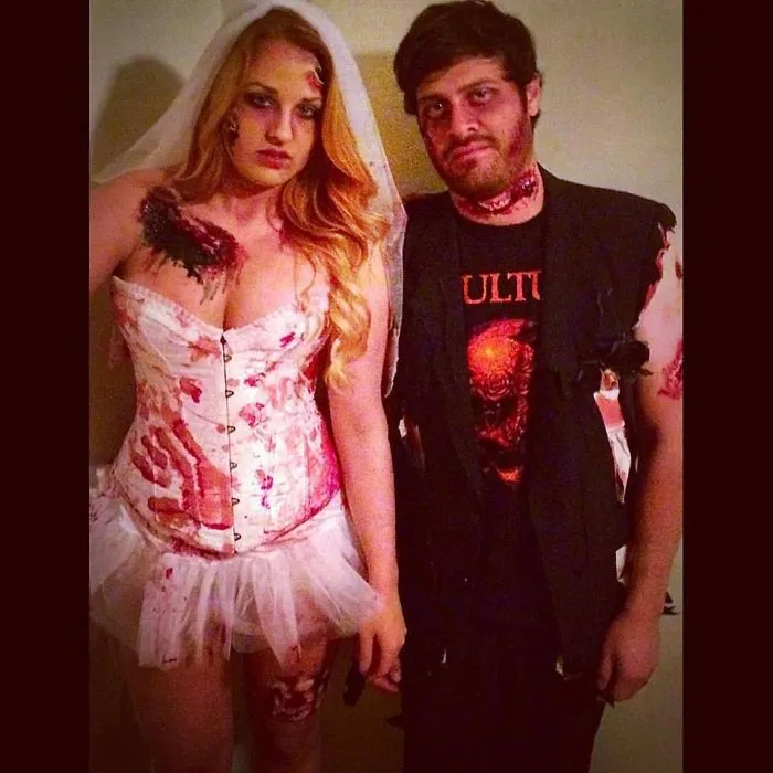 A couple dressed as a zombie bride and groom posing for creative Halloween costume ideas