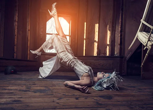 Creative photography shows a woman lying on a wooden floor, elegantly posing as if floating, highlighting photographic illusions.