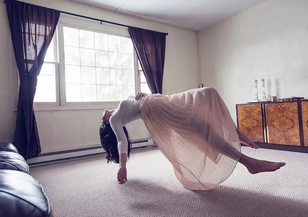 Person levitating in a living room, illustrating the deceptive nature of photography.