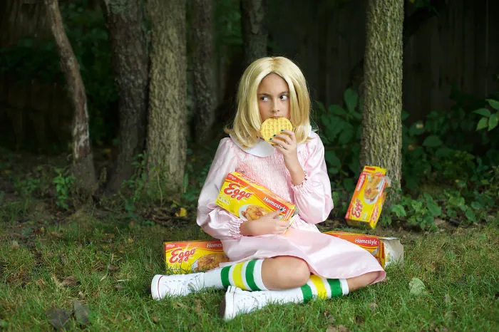 A girl dressed as Eleven from Stranger Things eating waffles as creative Halloween costume ideas
