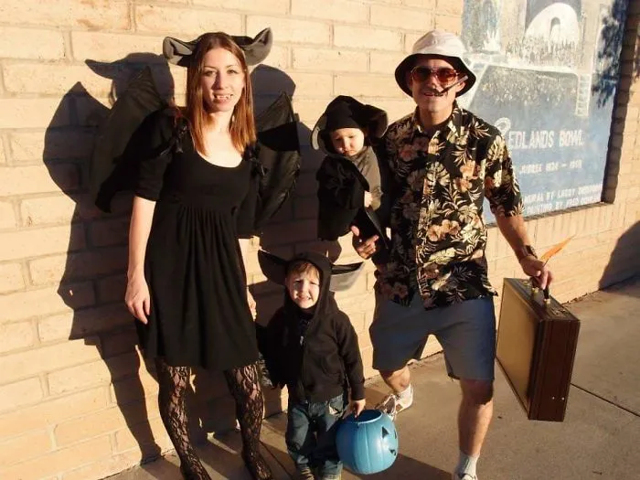 A family dressed in bat outfits and a Hawaiian shirt showing creative Halloween costume ideas.