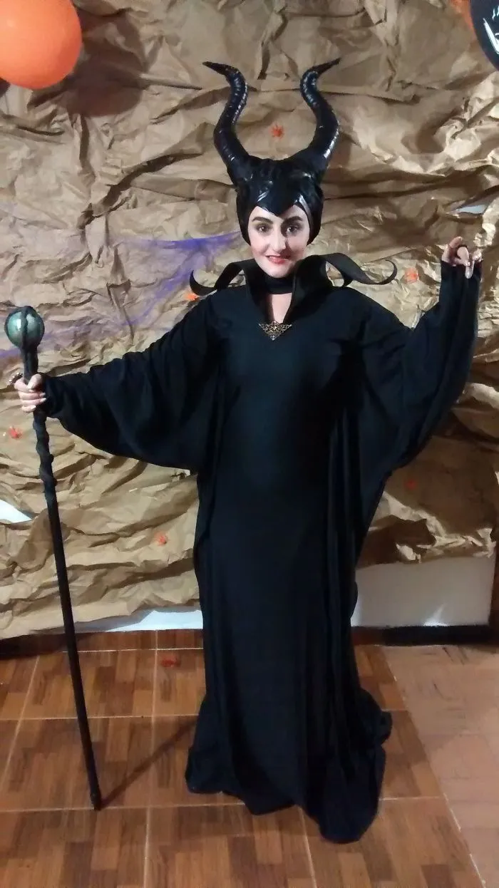 A person dressed as Maleficent in a black gown holding a staff for creative Halloween costume ideas
