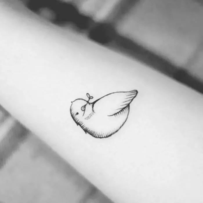Minimalist small bird tattoo design on forearm.