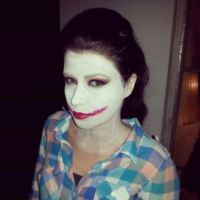 Woman wearing Joker makeup and plaid shirt as part of creative Halloween costume ideas