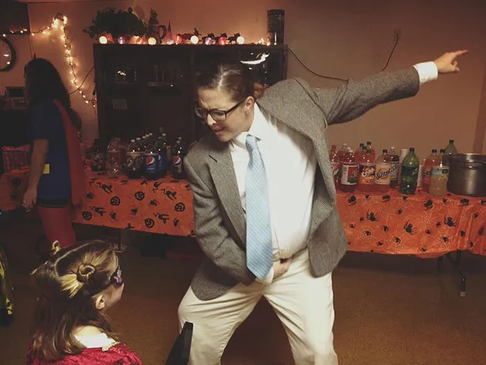 Person in a suit performing an energetic dance move showcasing creative Halloween costume ideas