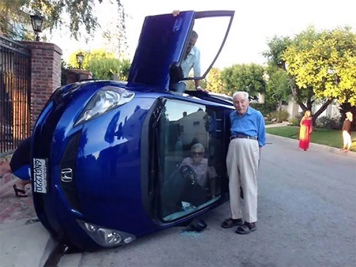 Making The Best Out Of A Bad Situation: Elderly Couple Pose For Photo After Their Car Flipped (Wife Still Trapped Inside)
