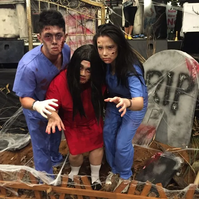 Three people dressed in zombie medical scrubs for a spooky creative Halloween costume concept
