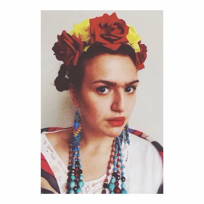 Woman wearing a floral crown and colorful beads styled as Frida Kahlo for creative Halloween costume ideas.