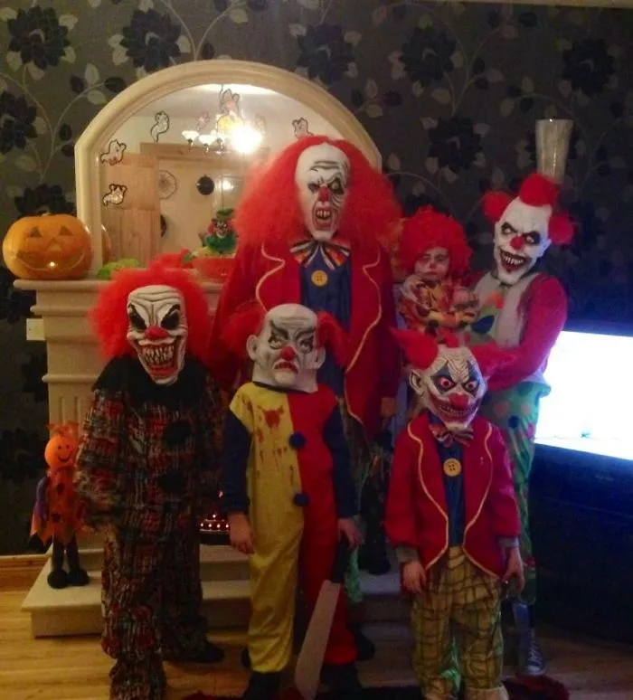 A group wearing scary clown Halloween costume ideas in a living room.