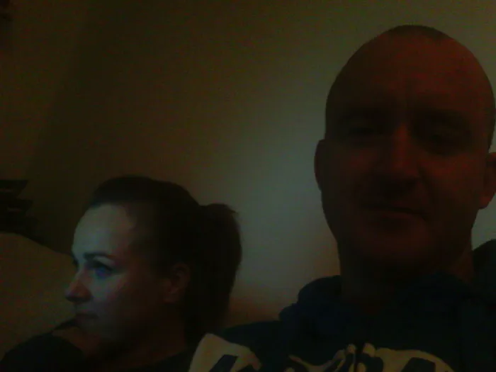 Man and woman sitting indoors with dim lighting, illustrating before-and-after pics of what happens when you stop drinking.
