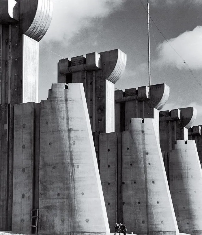 Massive concrete structures with unique tops against a cloudy sky, showcasing historical architecture in black and white photography.