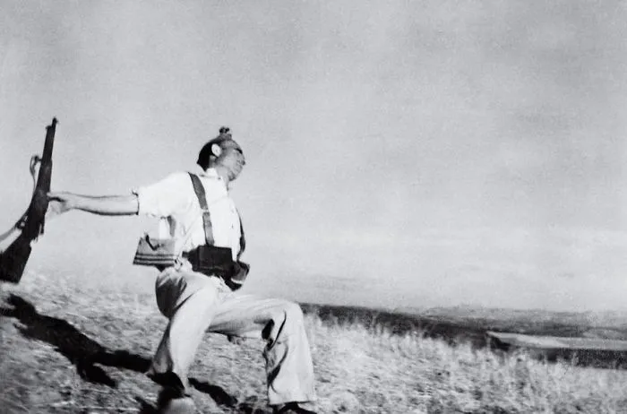 A soldier in battle captured in an iconic historic photo holding a rifle, depicting a dramatic wartime scene.