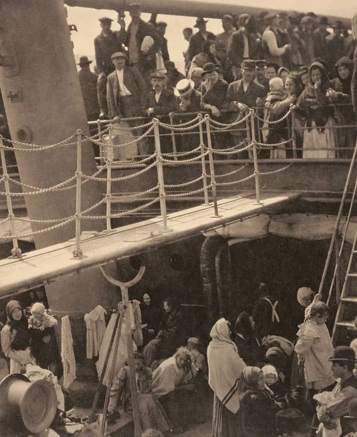 Historic photo of immigrants on a ship's deck, showcasing early 20th-century migration.