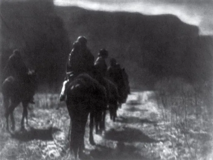 Group of riders on horseback in a historical black and white photograph, showcasing a famous moment in history.