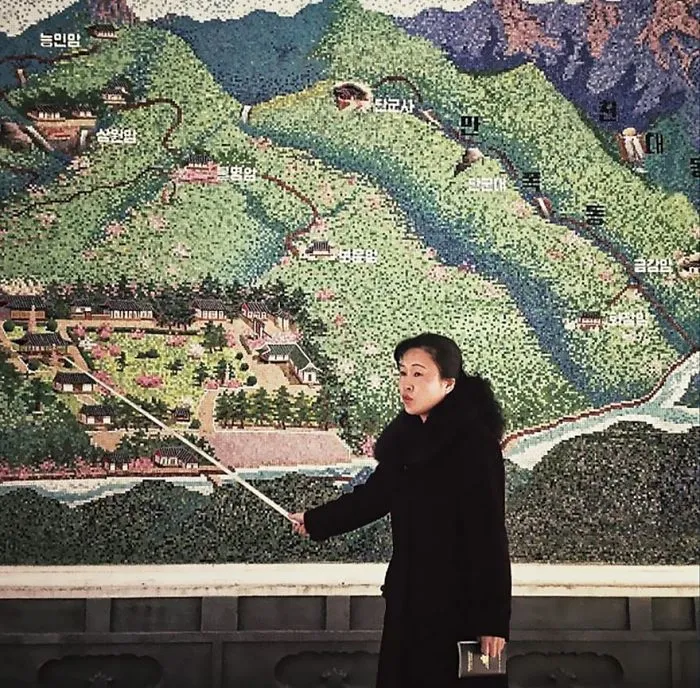 Woman pointing at a detailed map, highlighting historical significance, relating to famous photos in history.