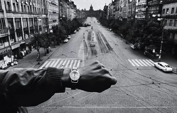A famous historical photo of a person checking time on a watch, overlooking an empty city street.