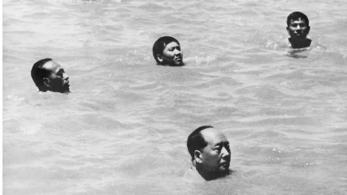 Four people swimming in a historical black and white photograph, capturing a famous moment in history.