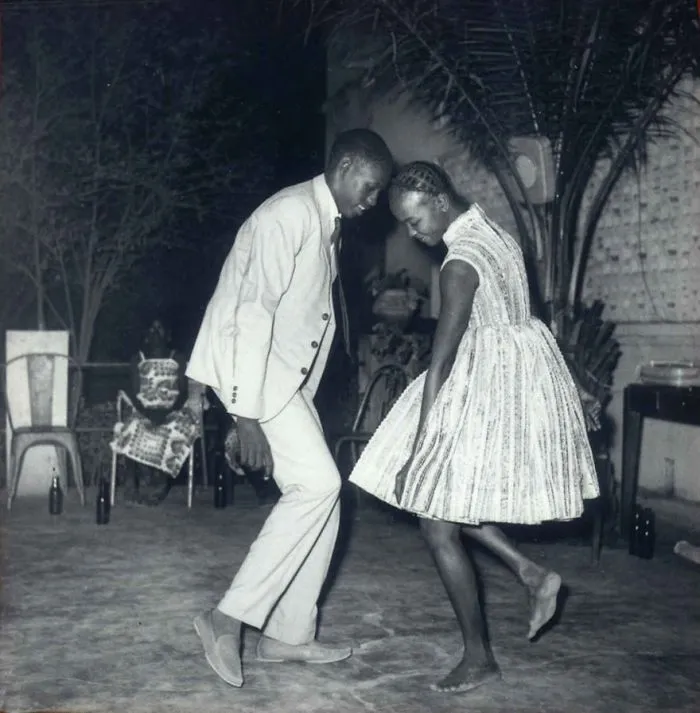 A couple dancing barefoot in a nostalgic black-and-white setting, capturing a famous moment in history.