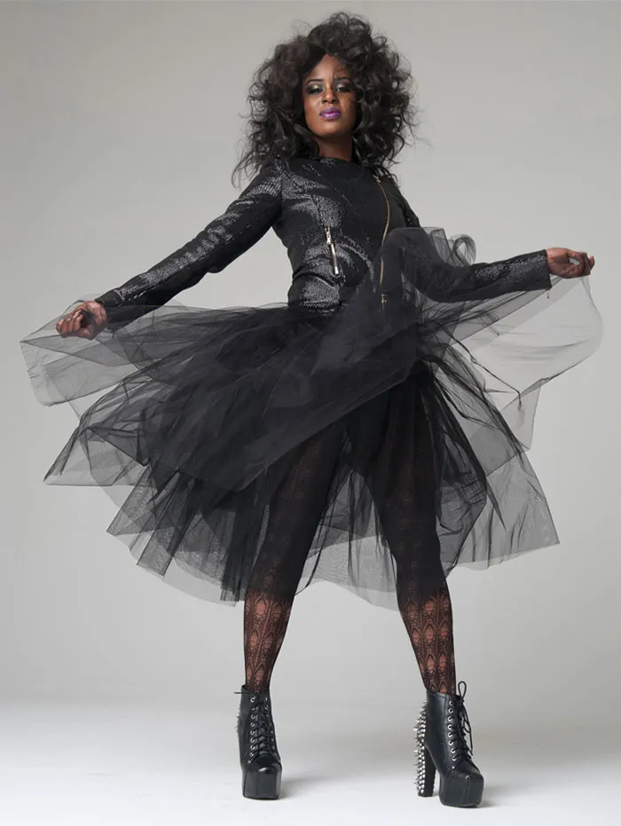 Fashion model in dramatic black dress and platform boots, showcasing transformation in beautiful photos before Photoshop.