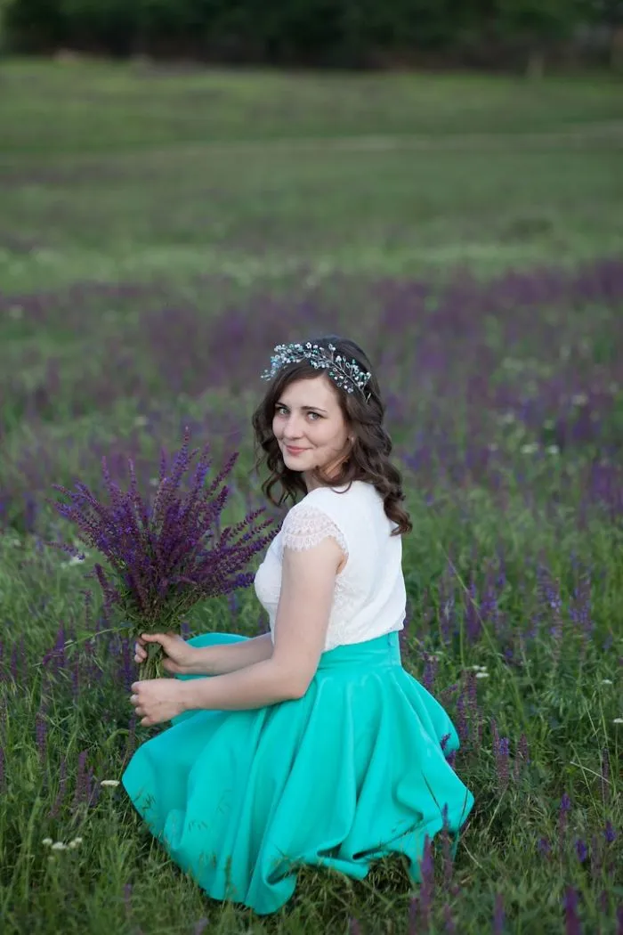 Woman in teal skirt holding lavender in a field, showcasing Photoshop's impact on beautiful photos.