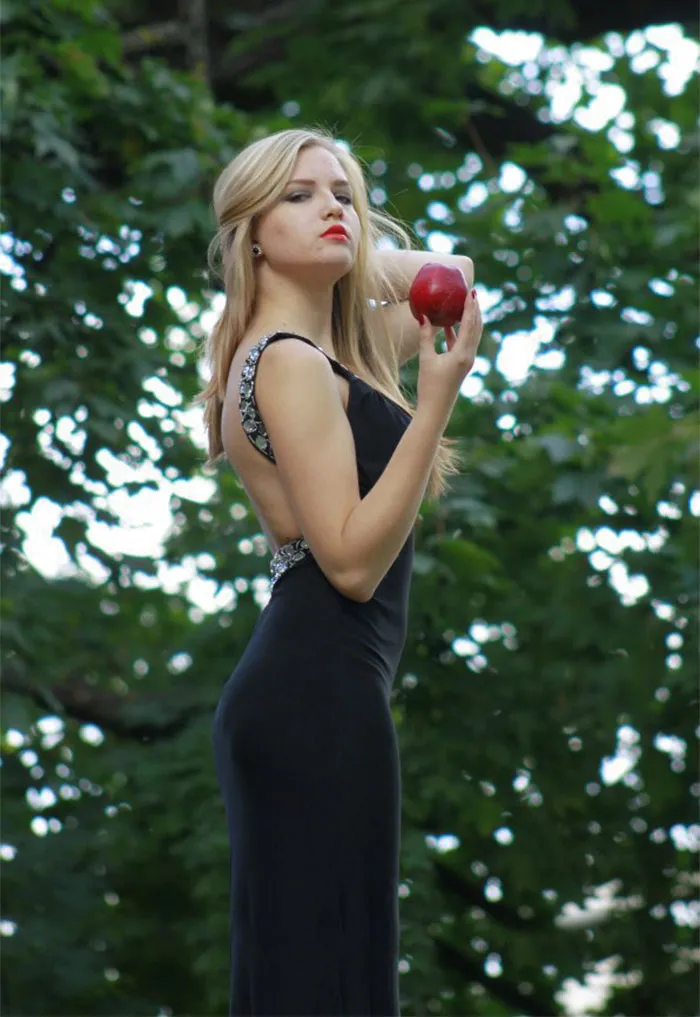 Woman in elegant dress holding an apple, showcasing photo retouching transformation.