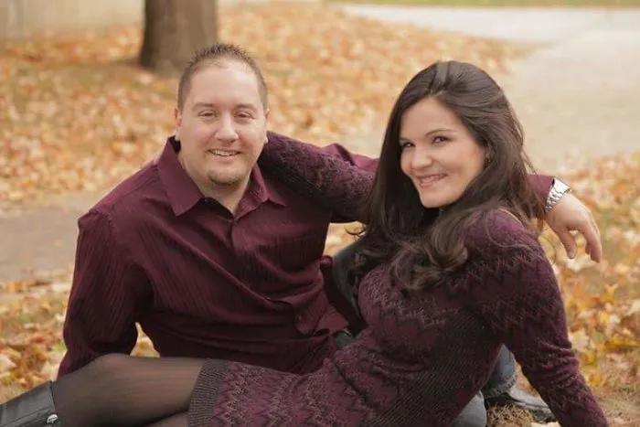 A smiling couple outdoors in autumn leaves, illustrating positive changes seen in before-and-after pics when you stop drinking.