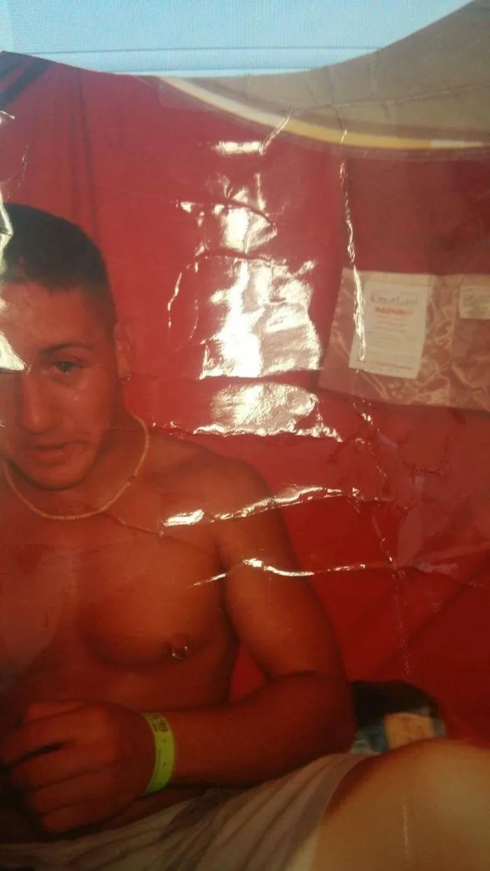 Young man sitting shirtless with a wristband, illustrating changes before and after quitting drinking in a casual setting.