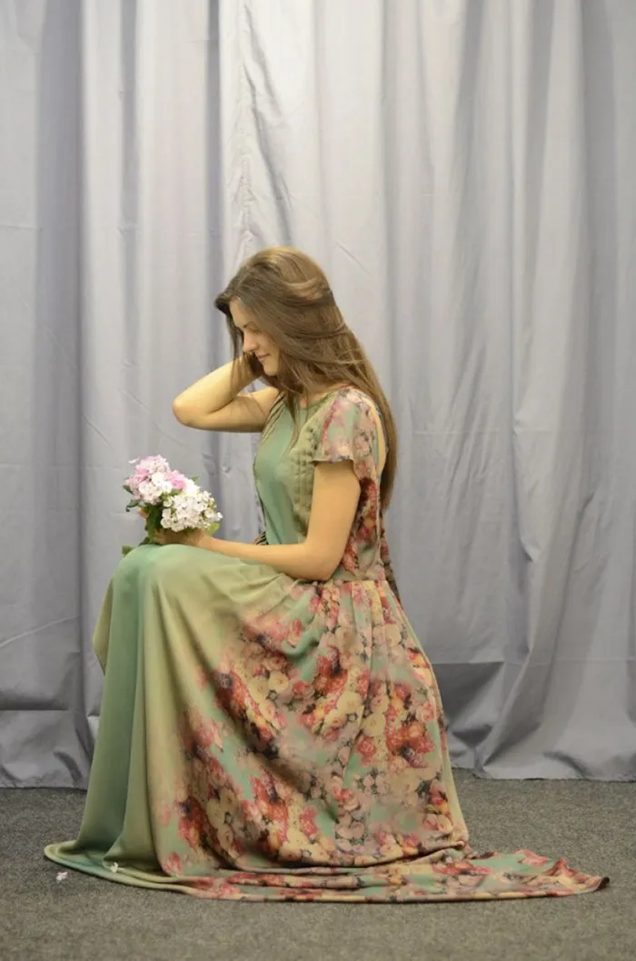 Woman in floral dress kneeling with flowers, showcasing the truth behind beautiful photos before Photoshop.