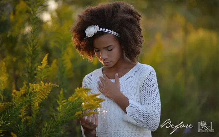 Young girl in a white dress holding yellow flowers, showcasing beauty before photoshop.