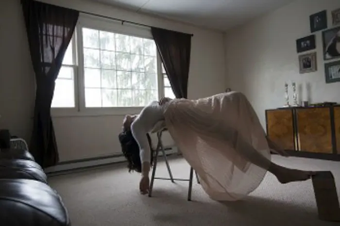 Person floating in a room with a window, highlighting the truth behind beautiful photos and Photoshop effects.